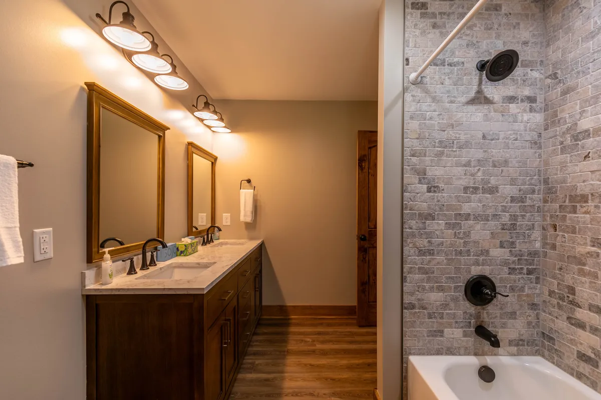 A spacious, serene bathroom featuring a double vanity with mirrors, a large shower, and a freestanding bathtub. Soft lighting and elegant finishes offer a spa-inspired atmosphere, perfect for relaxation and self-care.